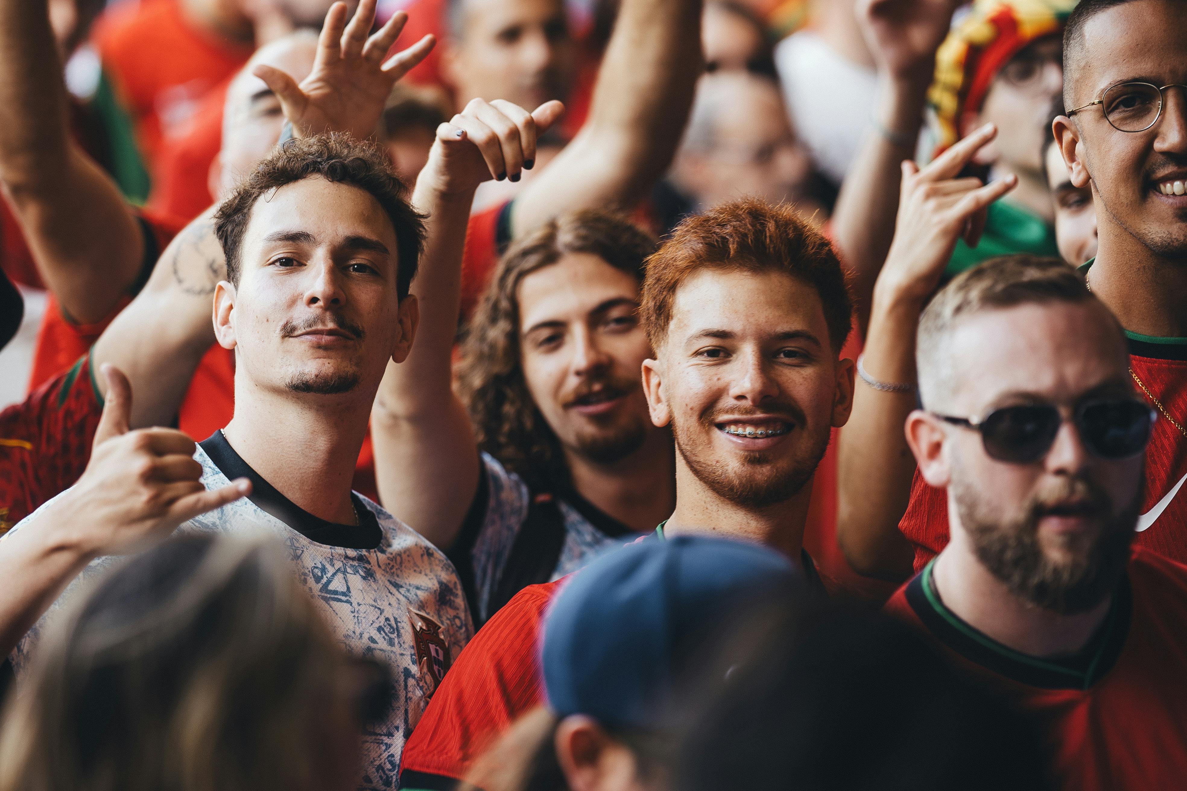 Men smiling in crowd of sporting event